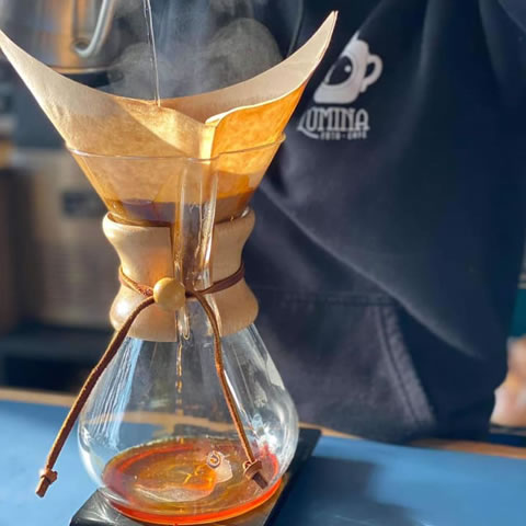 barista making a chemex coffee